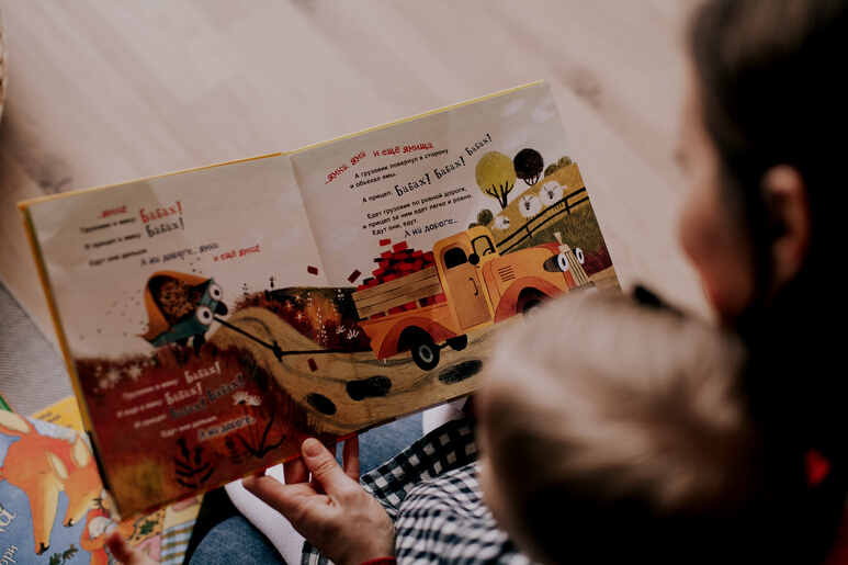 Woman Reading Book to Toddler